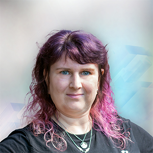Porträt einer Person mit lila Haaren, die direkt in die Kamera schaut, vor einem sanften, verschwommenen Hintergrund.