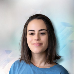 Junge Frau mit schulterlangen Haaren in blauem T-Shirt, lächelt vor einem hellen, abstrakten Hintergrund.