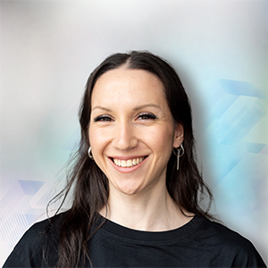 Porträt einer lächelnden Frau mit langen, dunklen Haaren vor einem abstrakten, hellen Hintergrund.